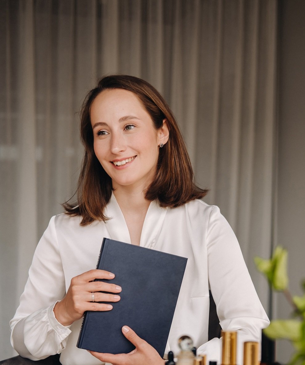 portrait of a smiling girl-woman sitting in an armchair. An aromatherapist in a white blouse is sitting in the office